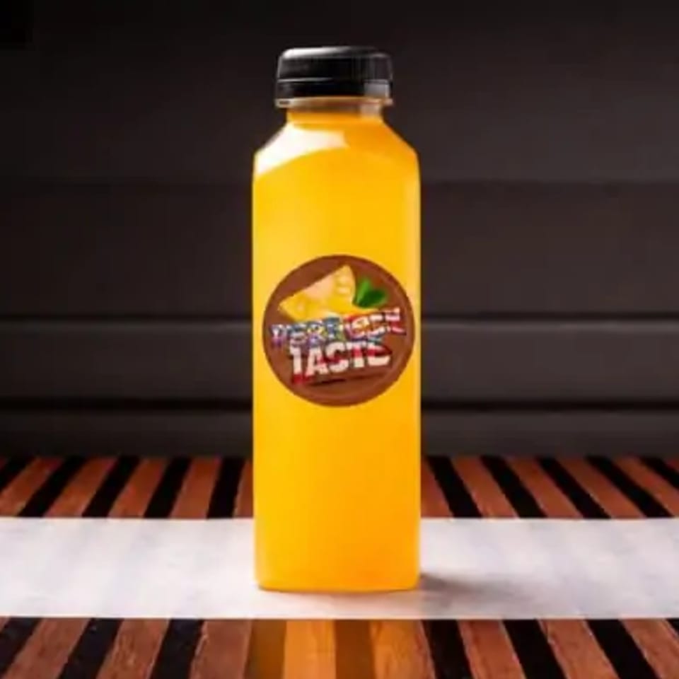 A yellow bottle of "Perfect Taste" juice with a brown label featuring a cheese slice and mint leaf.